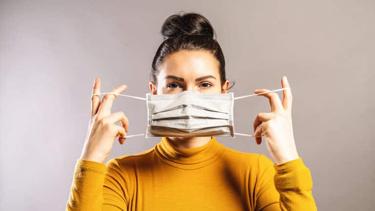 Woman putting on covid mask