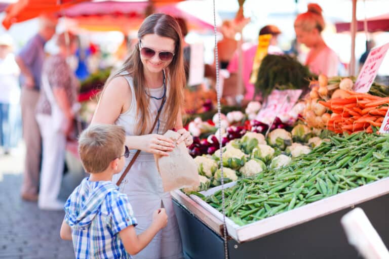 Mother and son buying food at an outdoor farmer's market